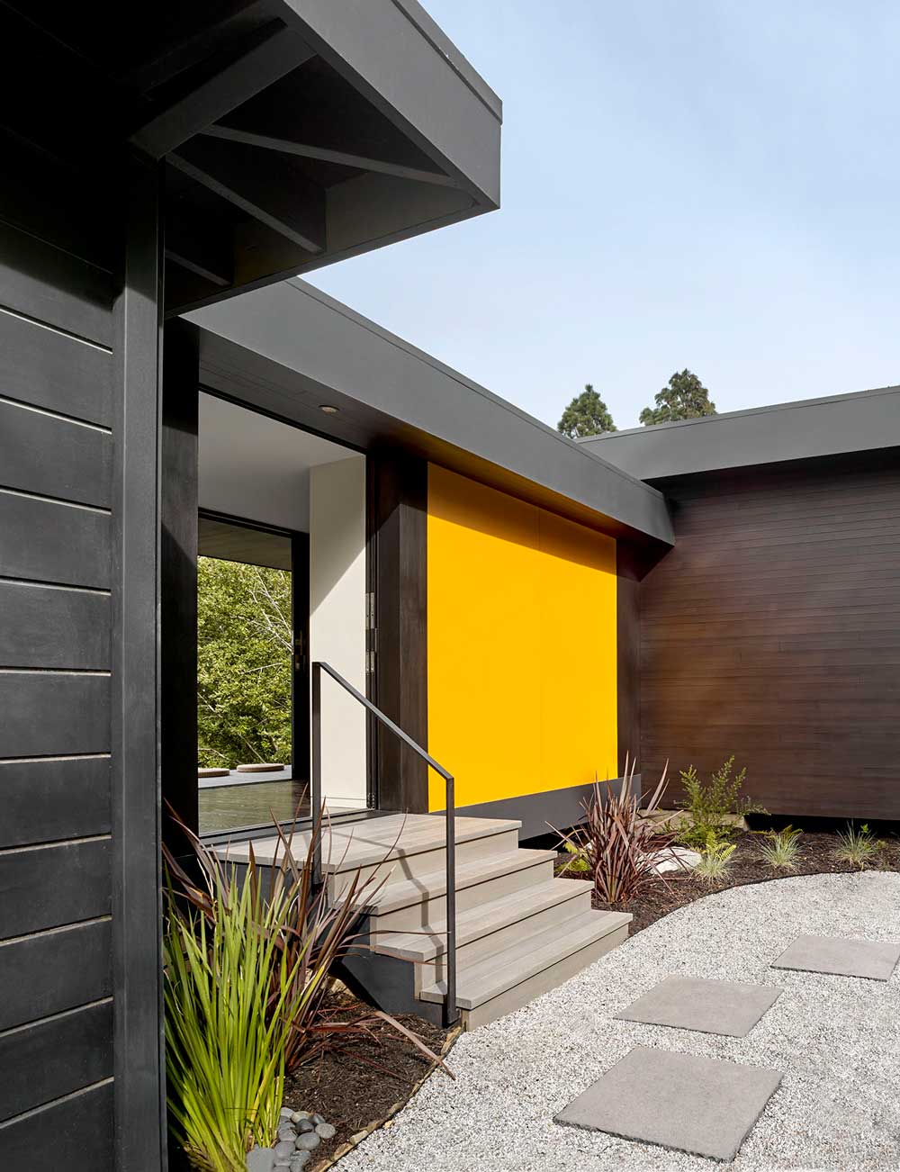 Marin Magazine, Large MDO (medium-density overlay) panels inspired by Japanese shoji screens secrete a pocket door at the front entrance, but instead of a discreet white, they are painted a bright California poppy yellow.
