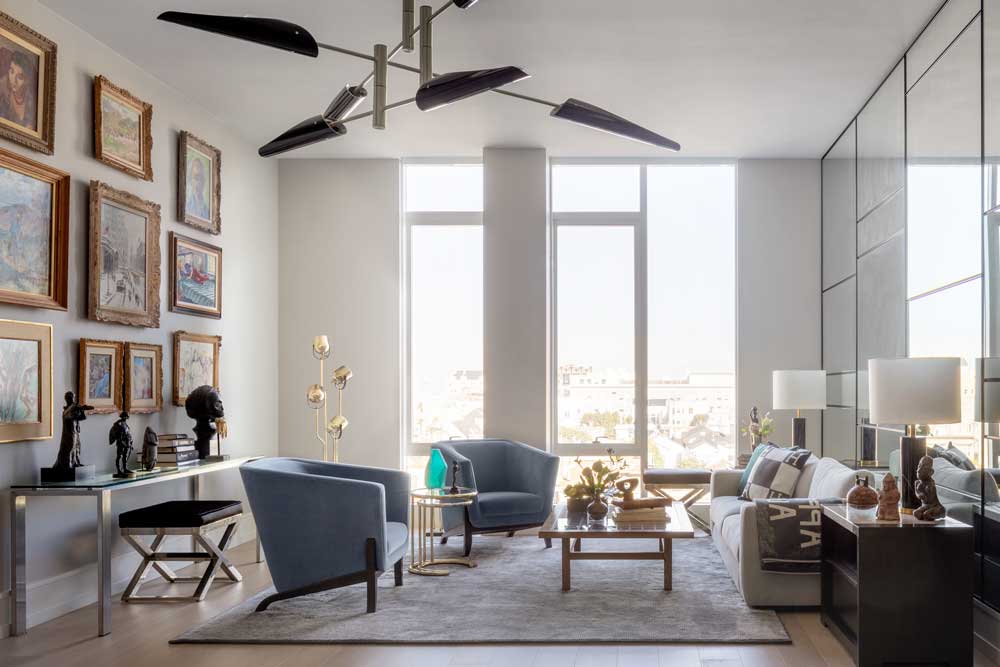 pale blue/gray paint, installed brighter LED lighting and, innovatively, added an inexpensive grid of mirrors to the living room’s east wall. They reflect light and make the living areas seem larger, and in their reflections you can view, from many angles, the most important paintings hung salon-style on the opposite wall. To protect the art from direct and ricocheted sunlight, ultraviolet-light-resistant shades come down automatically around sunset.